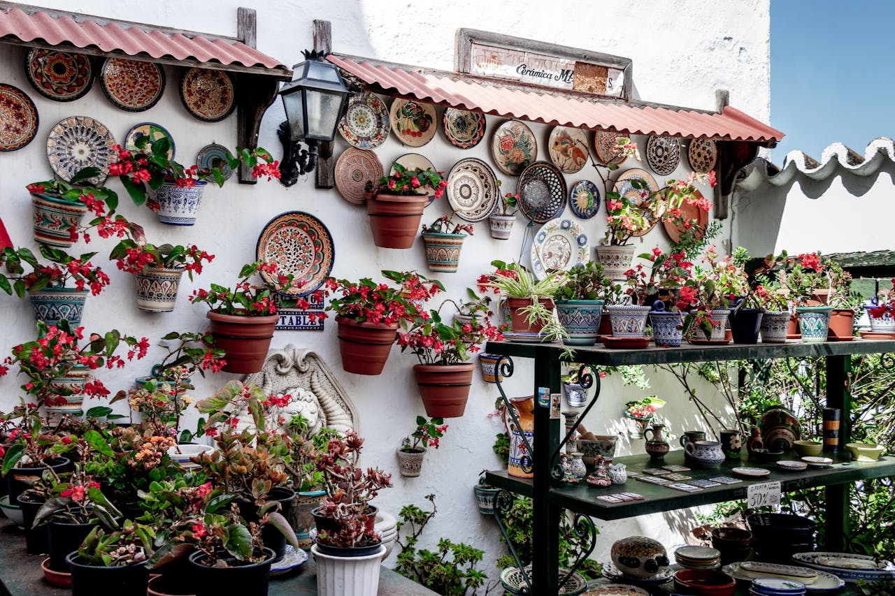 Vibrant decorative plates and flowers adorn a Mediterranean-style garden wall.